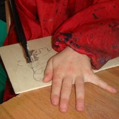 Kind schneidet mit Handsäge